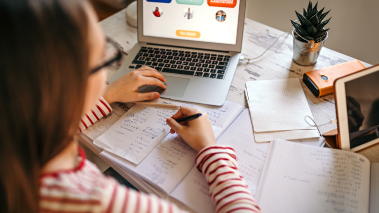 dziewczyna robi notatkę i uczy się przy komputerze